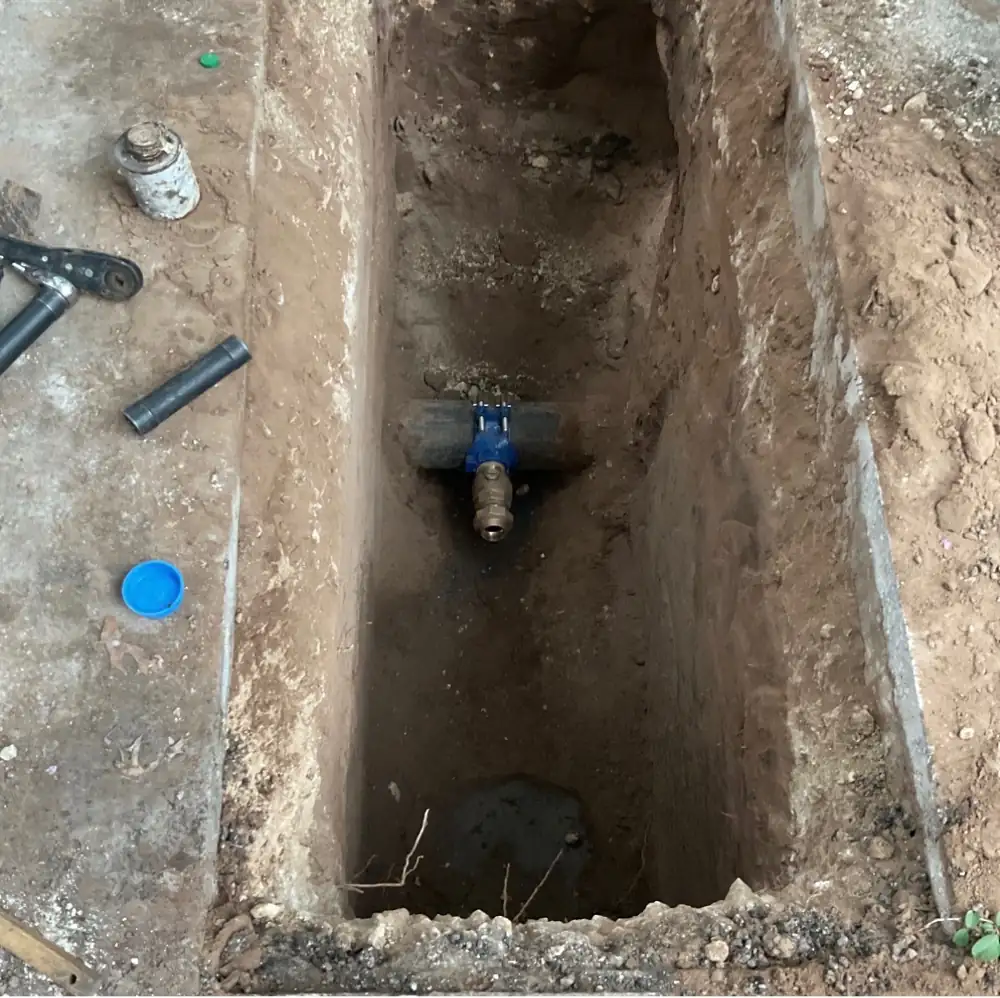 Water valve and tapping saddle installed in an excavated trench ahead of the meter connection